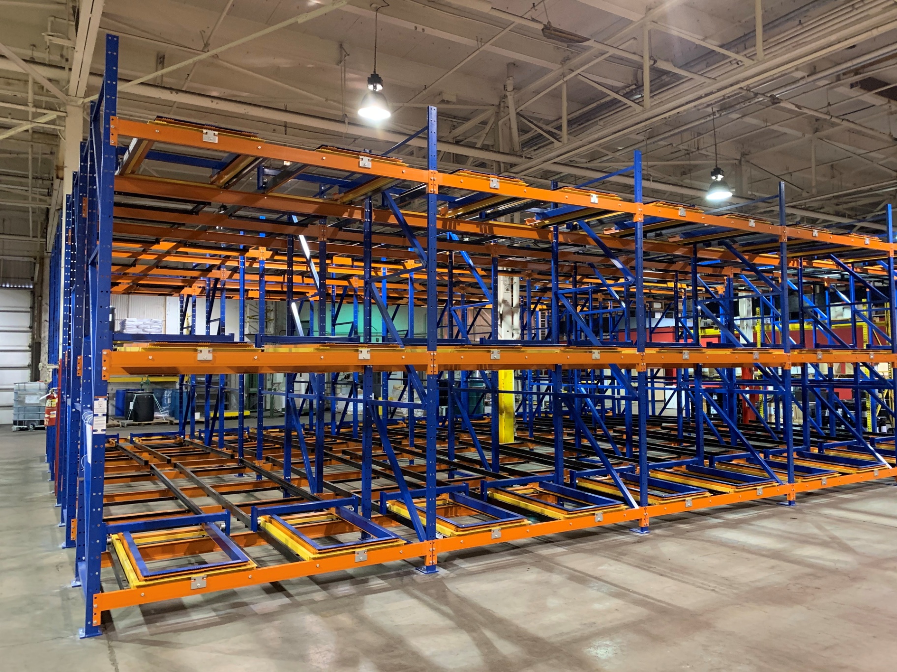 Push back pallet racking with blue uprights and orange nested carts